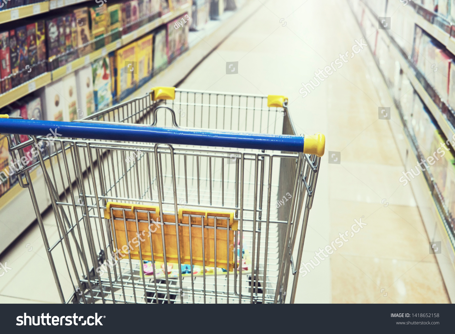 Empty shopping trolley cart in shopping mall interior background. Toy store, Bookstore, household and household goods #1418652158