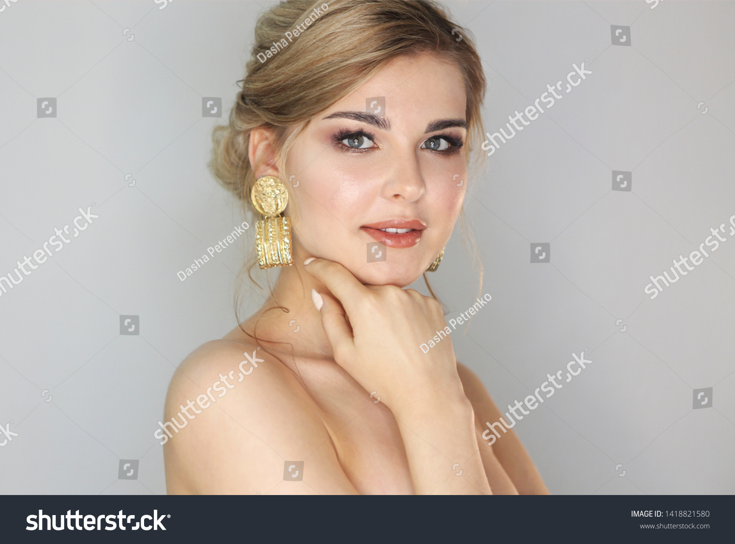 Portrait of the blond woman with fashion hairstyle and makeup wearing big golden earrings #1418821580