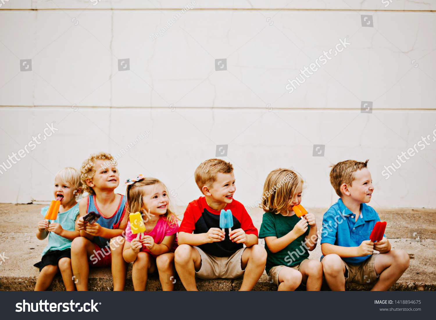Group of Kids Eating Colorful Frozen Popsicles in the Summer #1418894675