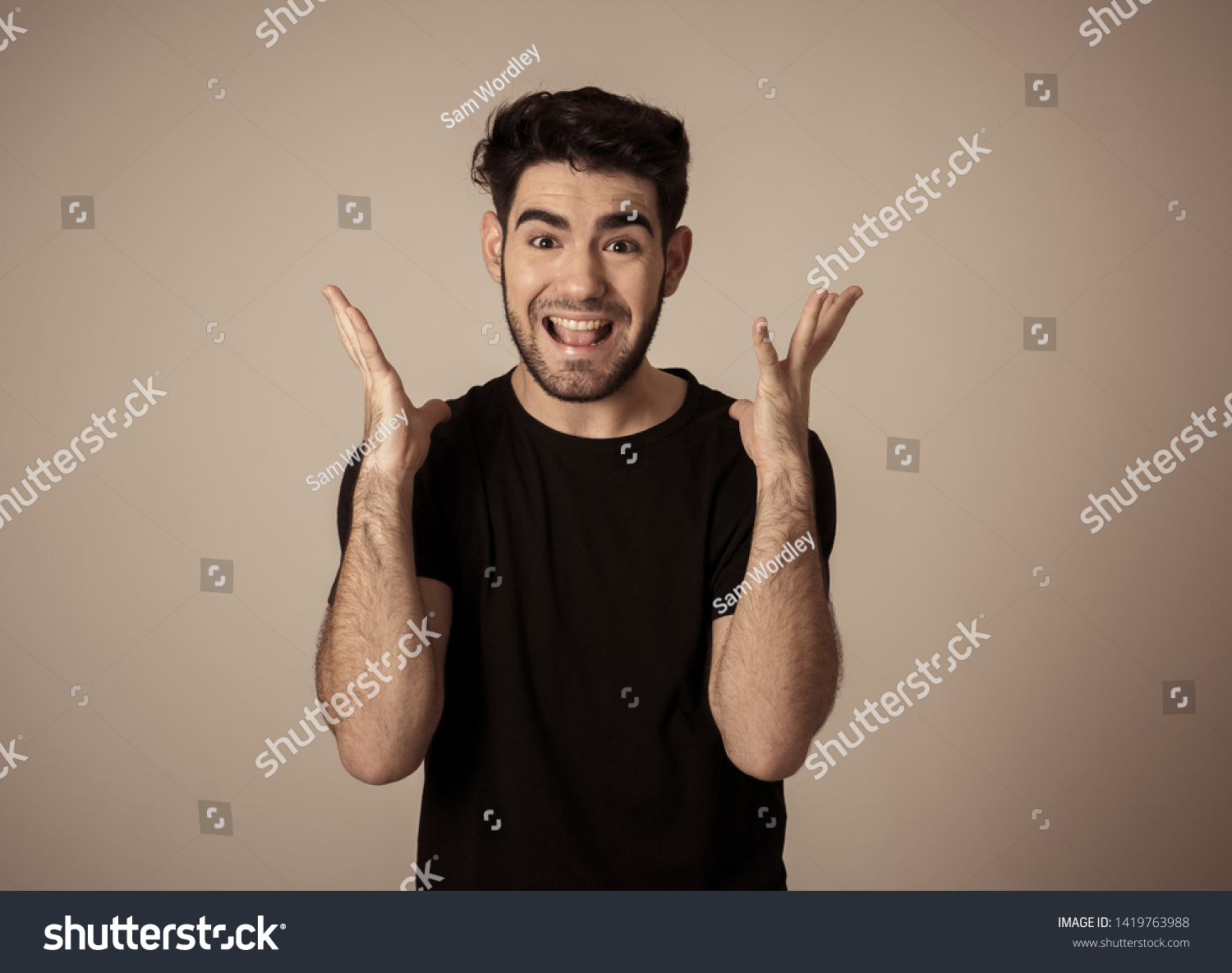 Portrait of a handsome latin young man surprised and shocked hearing great news. Attractive male looking amazed with wide eyes and mouth open in surprise. Human facial expressions and emotions. #1419763988