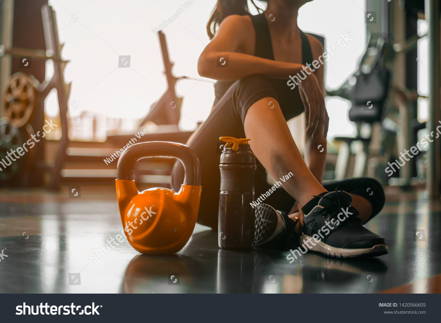 
fitness ,workout, gym exercise ,lifestyle  and healthy concept.Fitness woman Relaxing after exercise with a whey protein and dumbbell placed beside the gym.Relaxing after training. #1420566605