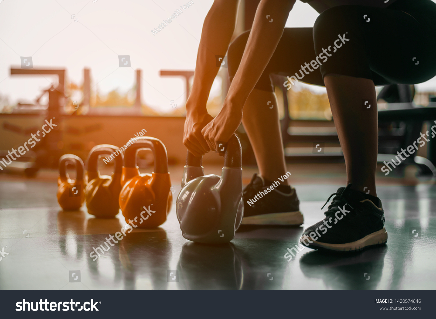fitness ,workout, gym exercise ,lifestyle  and healthy concept.Woman in exercise gear standing in a row holding dumbbells during an exercise class at the gym.Fitness training with kettlebell in sport  #1420574846