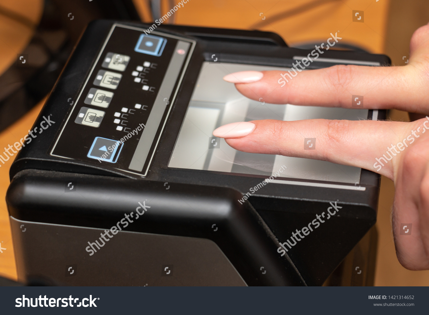 The process of scanning fingerprints during the check at border crossing. Female hand puts fingers to the fingerprint scanner. Biometric, identity verification and border control, immigration concept #1421314652