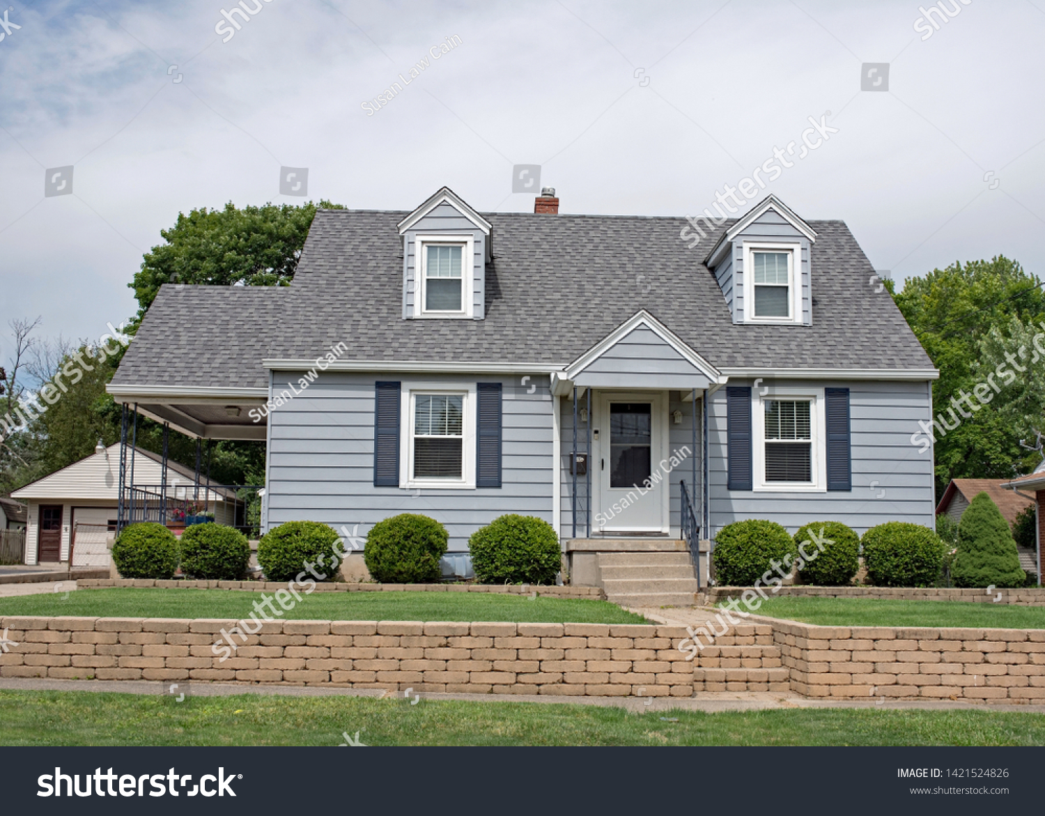 Little Blue Cape Cod House with Tan Brick Wall #1421524826