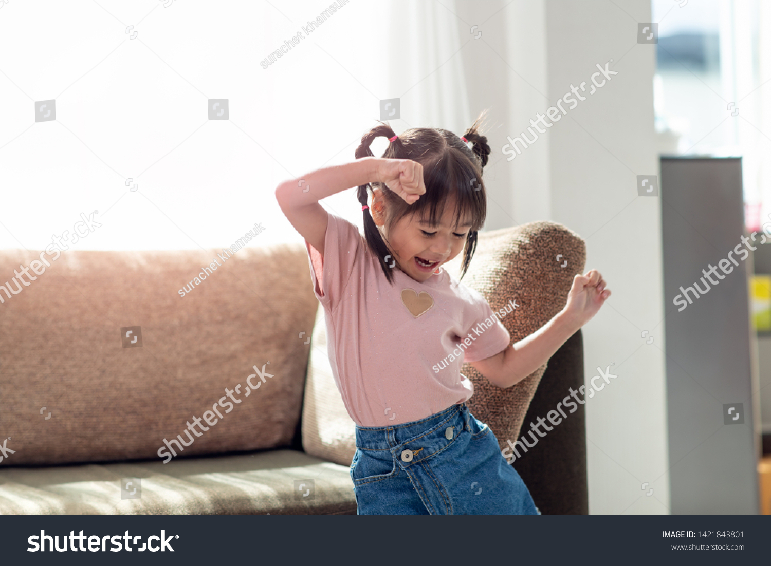 Happy Asian child having fun and dancing in a room, active leisure and lifestyle concept #1421843801