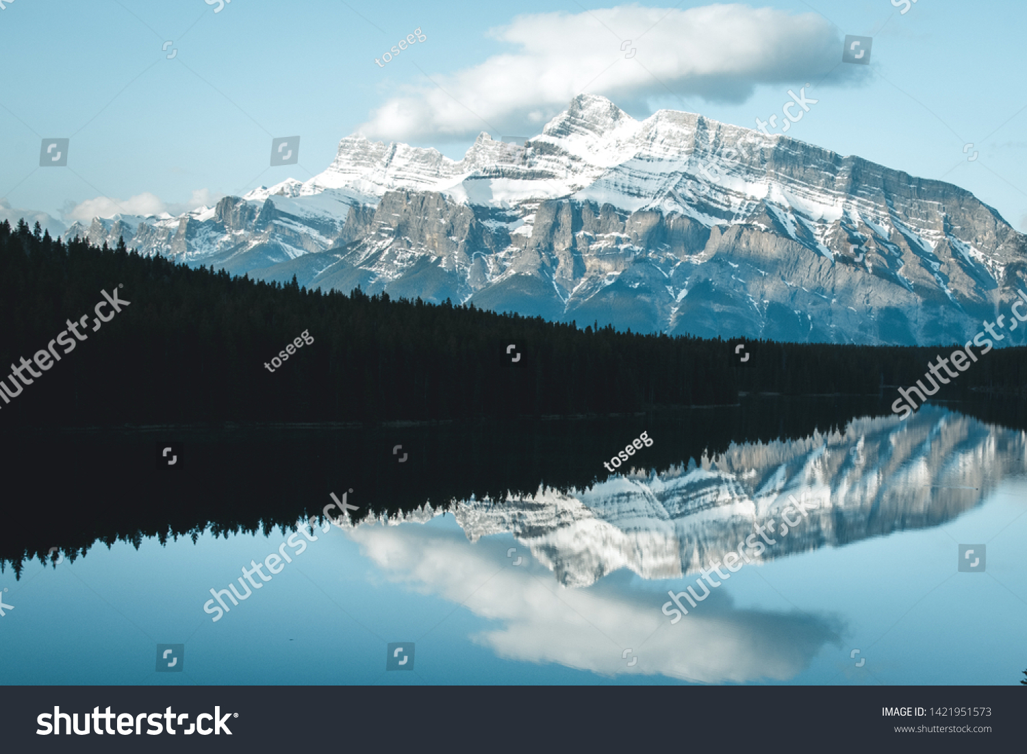 Mountain reflecting in a calm lake #1421951573