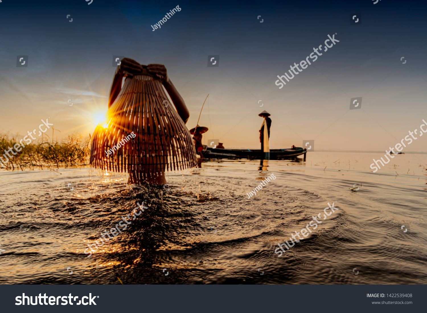 Image is silhouette. Fishermen Casting are going out to fish early in the morning with wooden boats, old lanterns and nets. Concept Fisherman's life style
 #1422539408