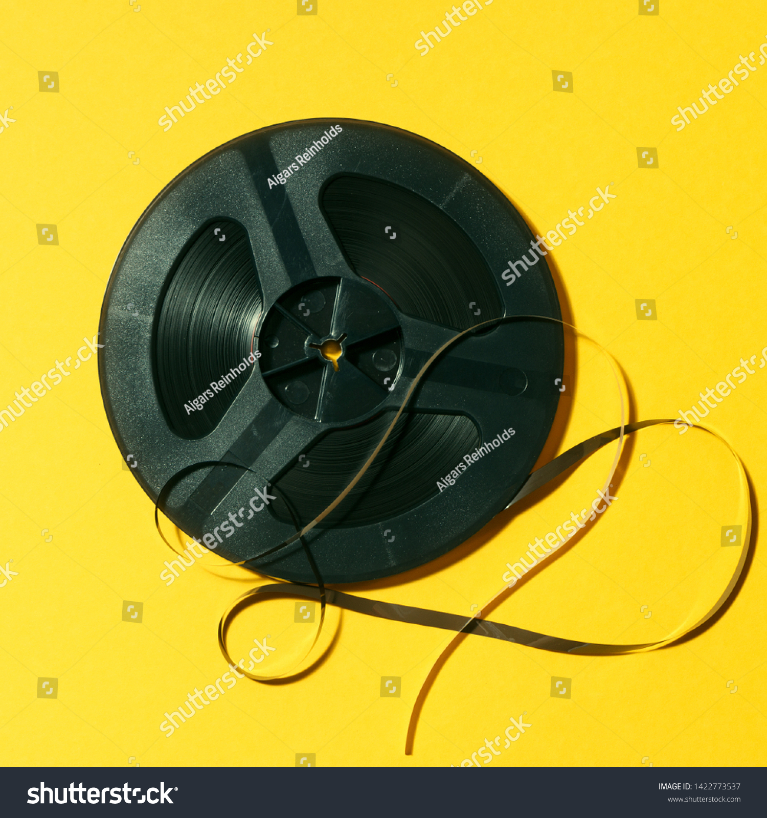 reel-to-reel tape in spool on a yellow background #1422773537