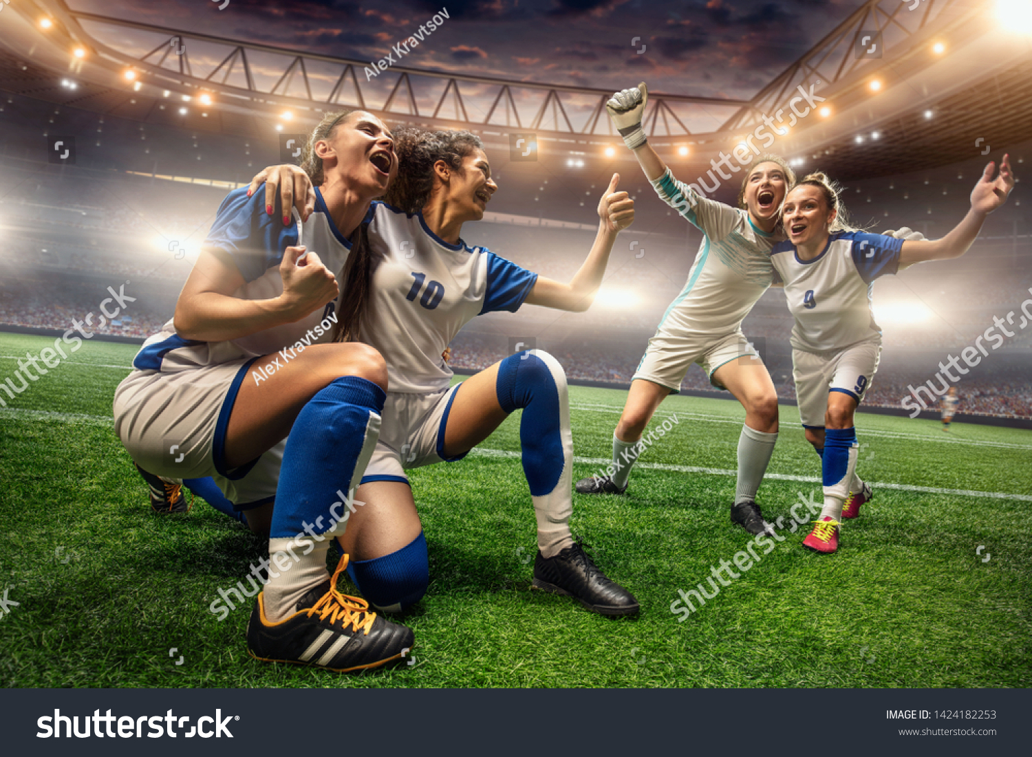 Happy Female Soccer players on a professional soccer stadium. Girls Team emotionally celebrates victory #1424182253