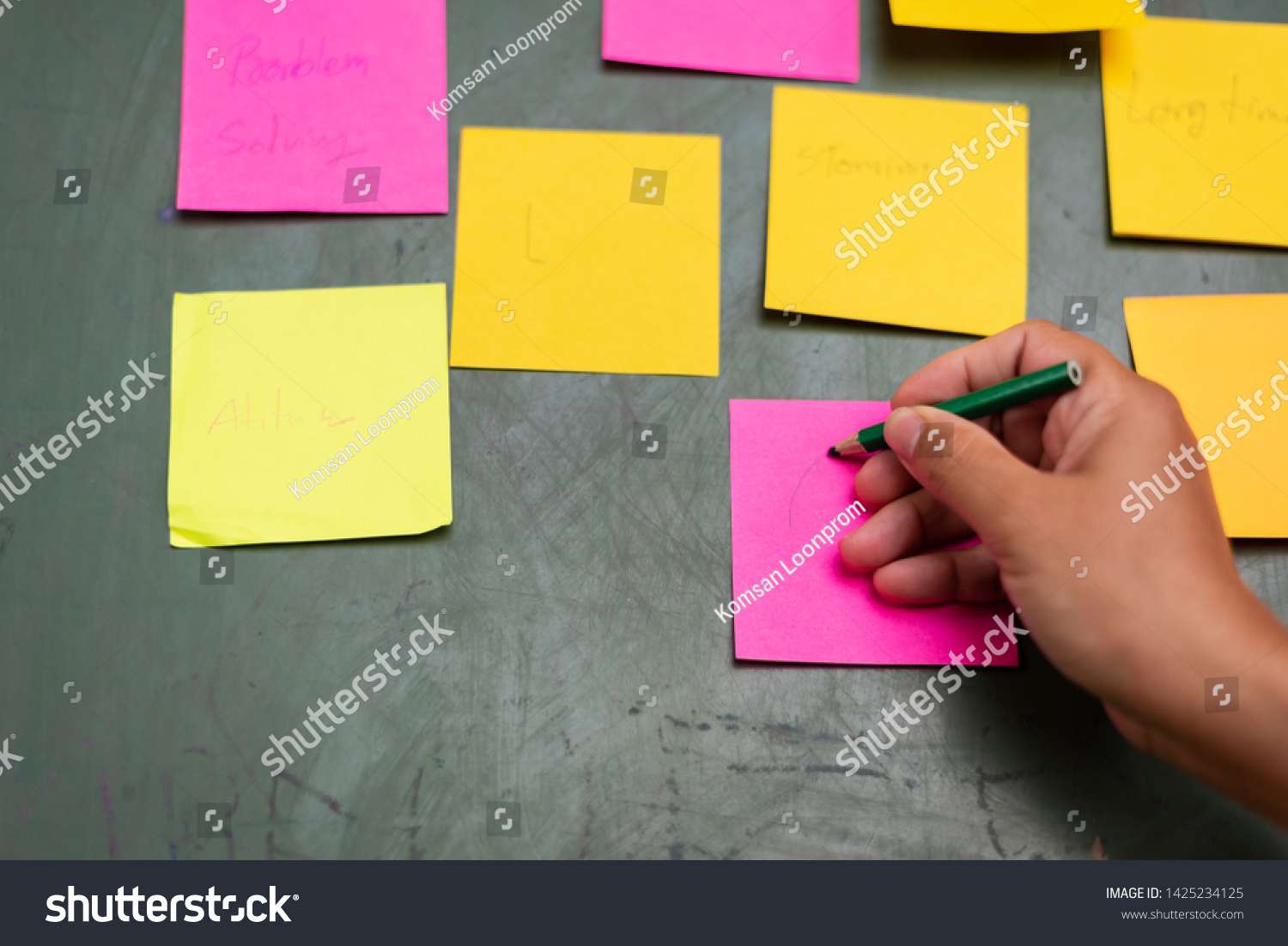 Close up woman hand writing colorful note sticky for brainstorm and share idea strategy workshop business.Brainstorming concept. #1425234125