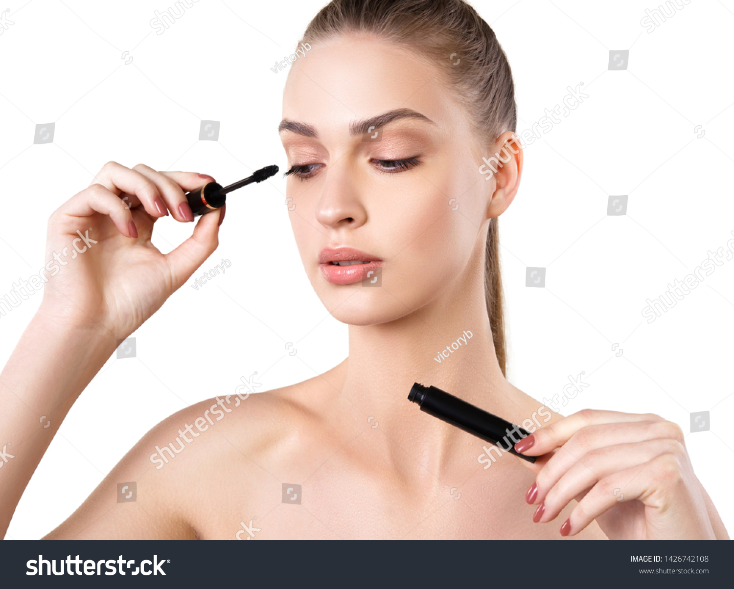 Beautiful woman applying mascara on her eyelashes #1426742108