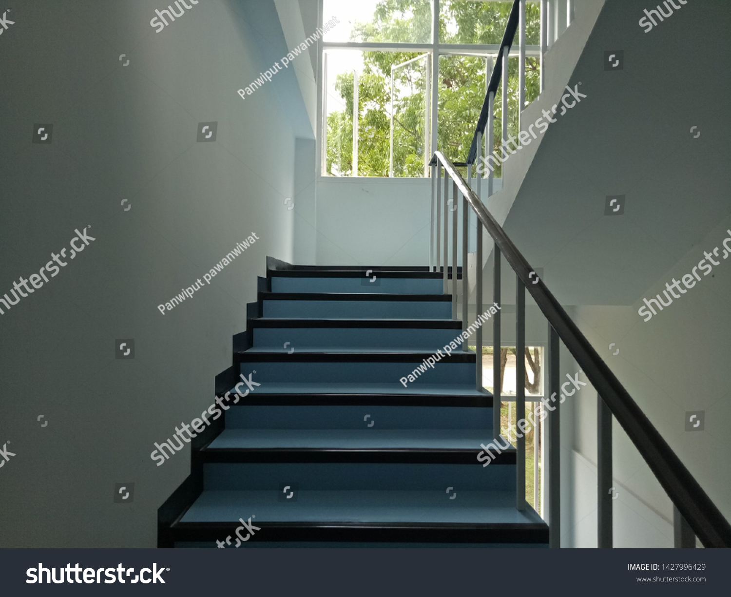 Walkway.Blue stairs.Narrow stairs.Walls and stairs.Stairs inside the building #1427996429