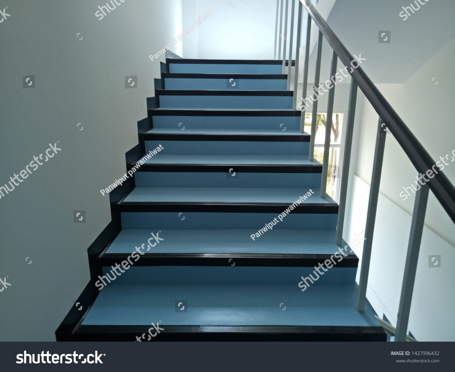 Walkway.Blue stairs.Narrow stairs.Walls and stairs.Stairs inside the building #1427996432