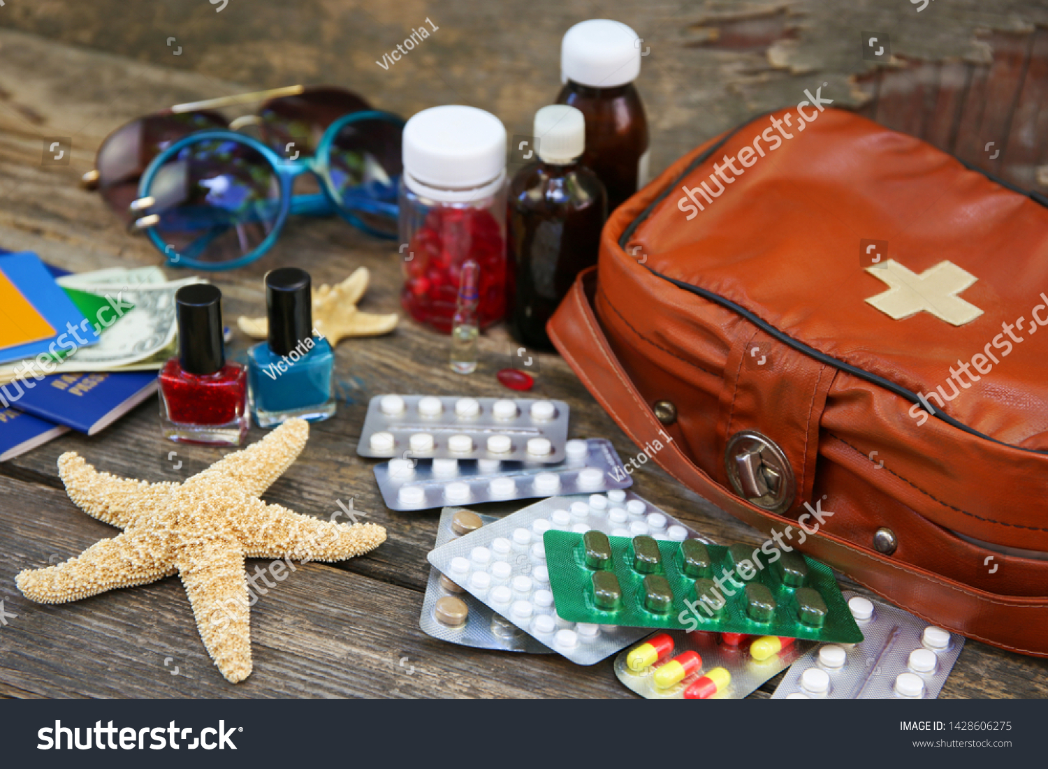 Summer women's beach accessories for your sea holiday and first aid kit on old wooden background. Concept of medication required in journey. Top view. Flat lay. #1428606275