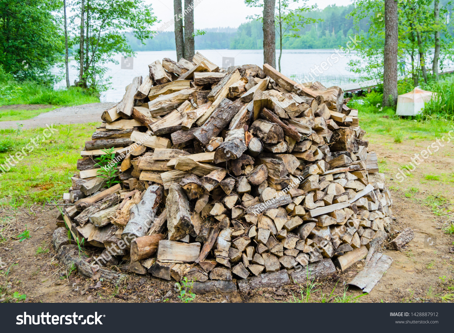firewood piled in one pile outdoors against the backdrop of nature #1428887912