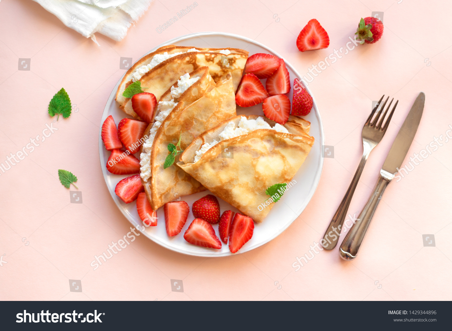 Crepes with ricotta cheese and fresh strawberries on pink pastel background, top view, copy space. Delicious crepes, thin pancakes. #1429344896