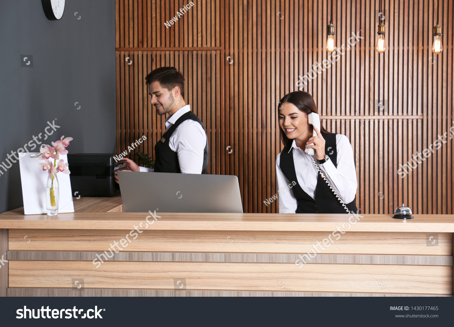 Receptionists working at desk in modern lobby #1430177465