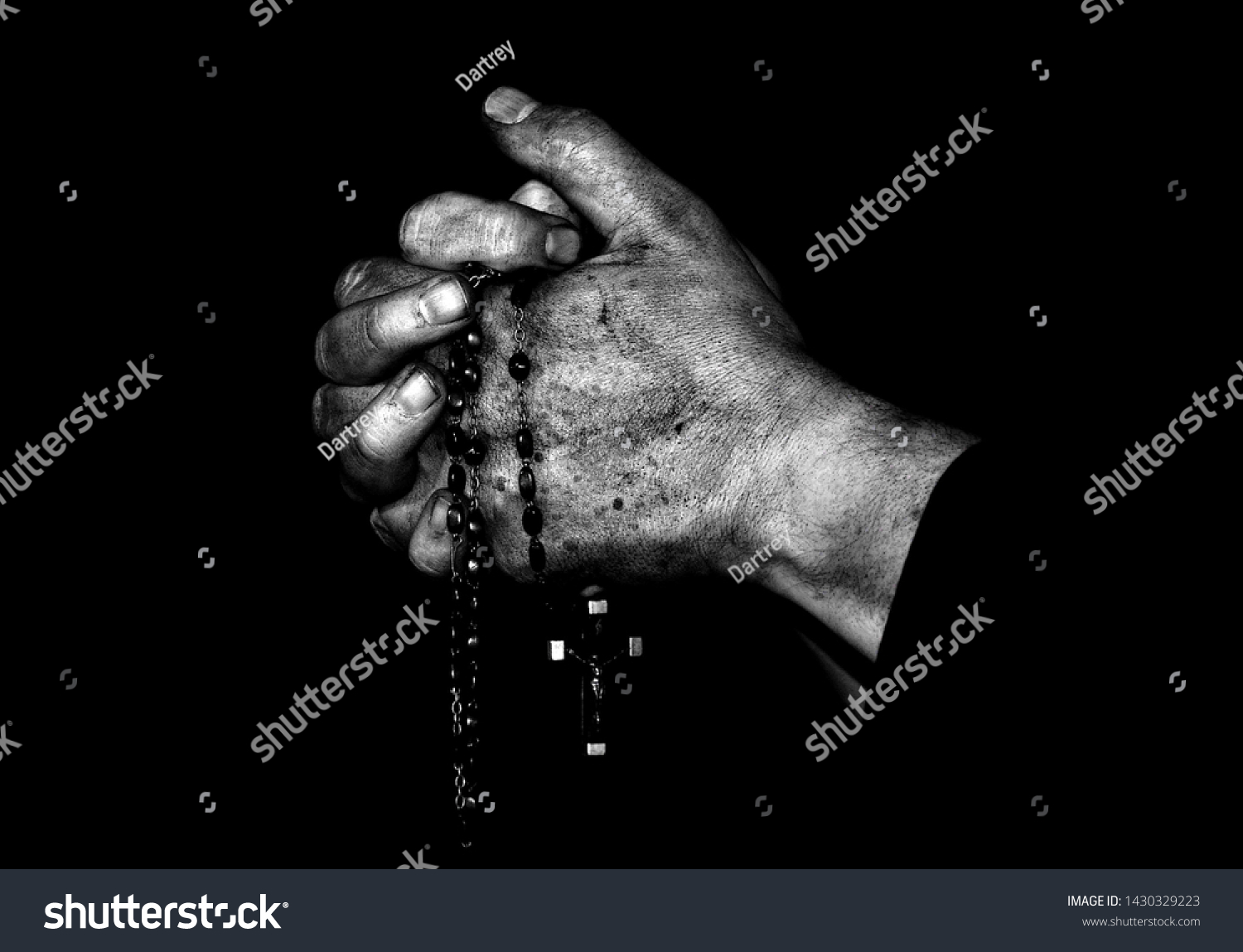 Hands clasped in prayer clutching a rosary #1430329223