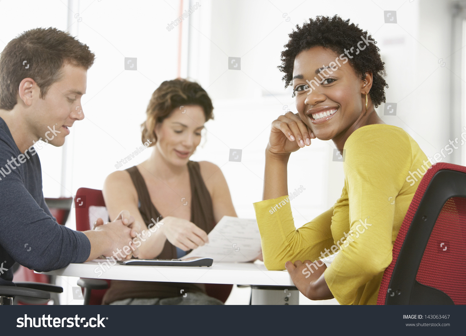 Portrait of young businesswoman with colleagues in meeting room #143063467