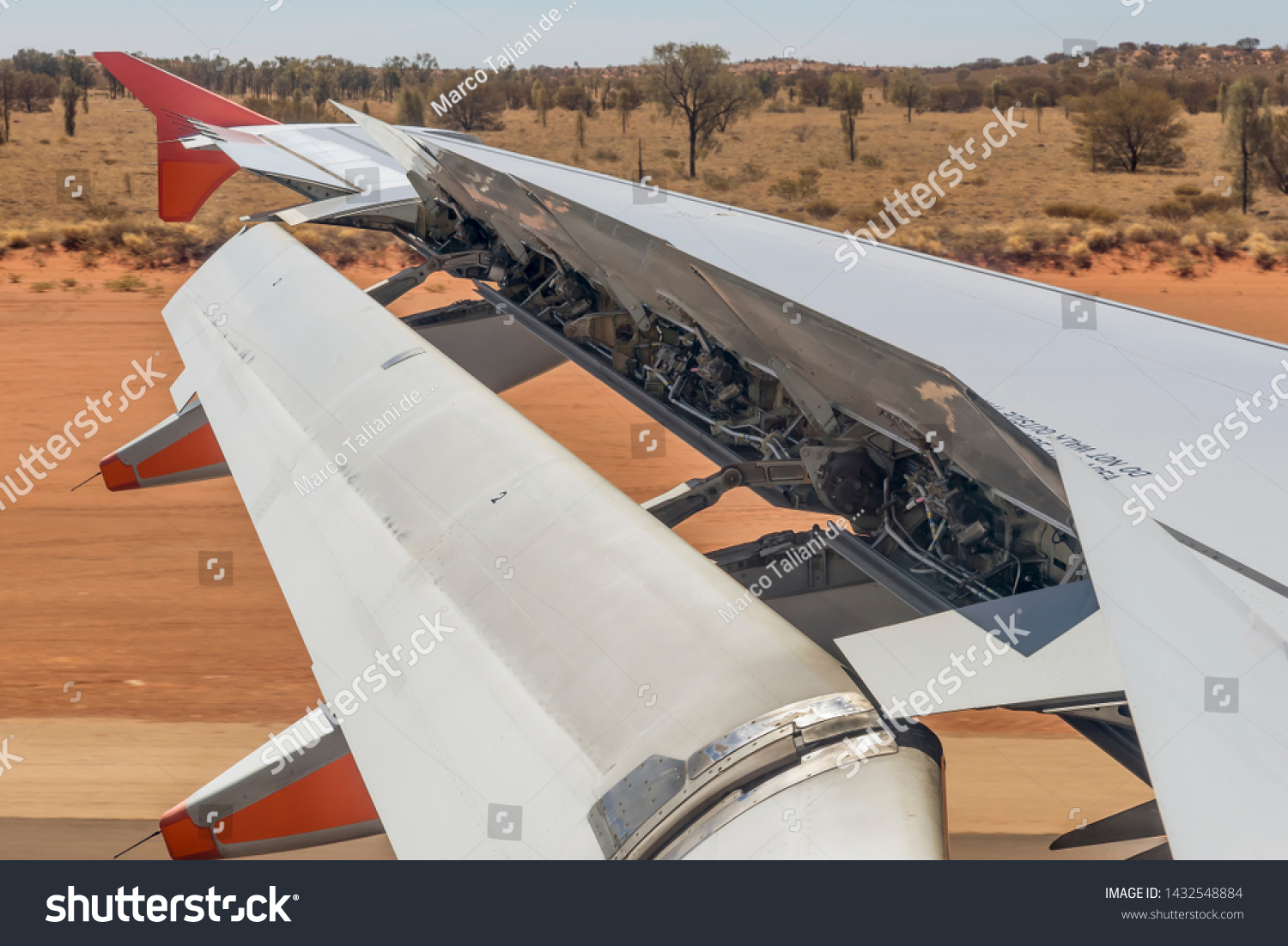 Airplane activates ground spoilers as it lands at the Ayers Rock airport in Australia #1432548884