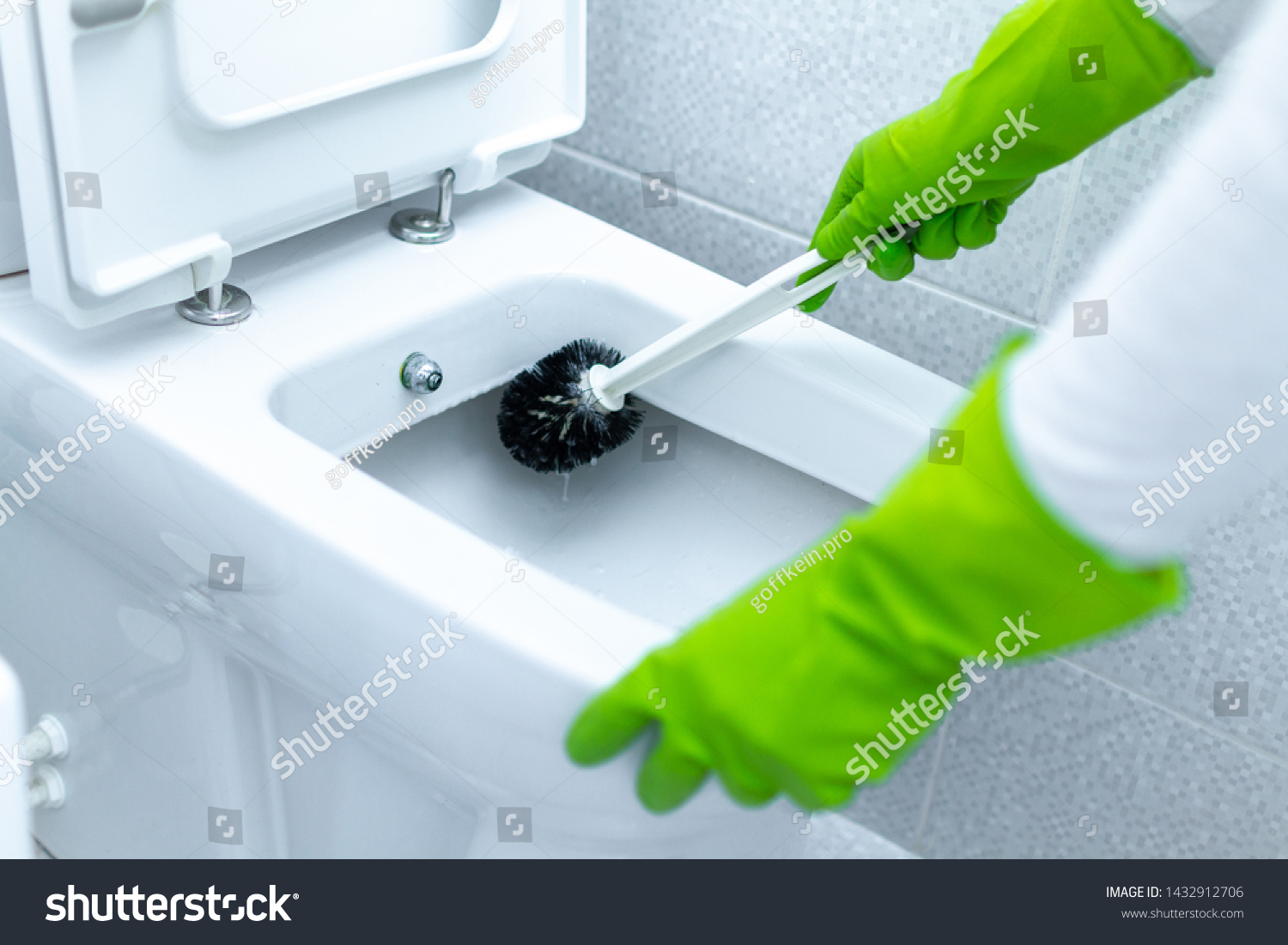 Washing and disinfecting toilet using cleaning scrub brush. Cleaning service and household chores #1432912706