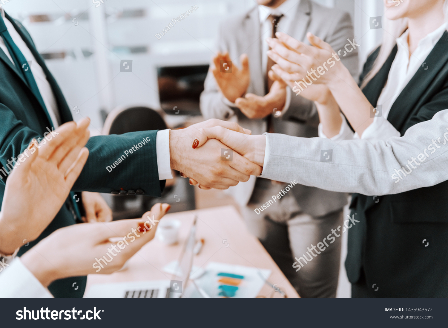 Close up of two business partners shaking hands. Colleagues clapping. #1435943672