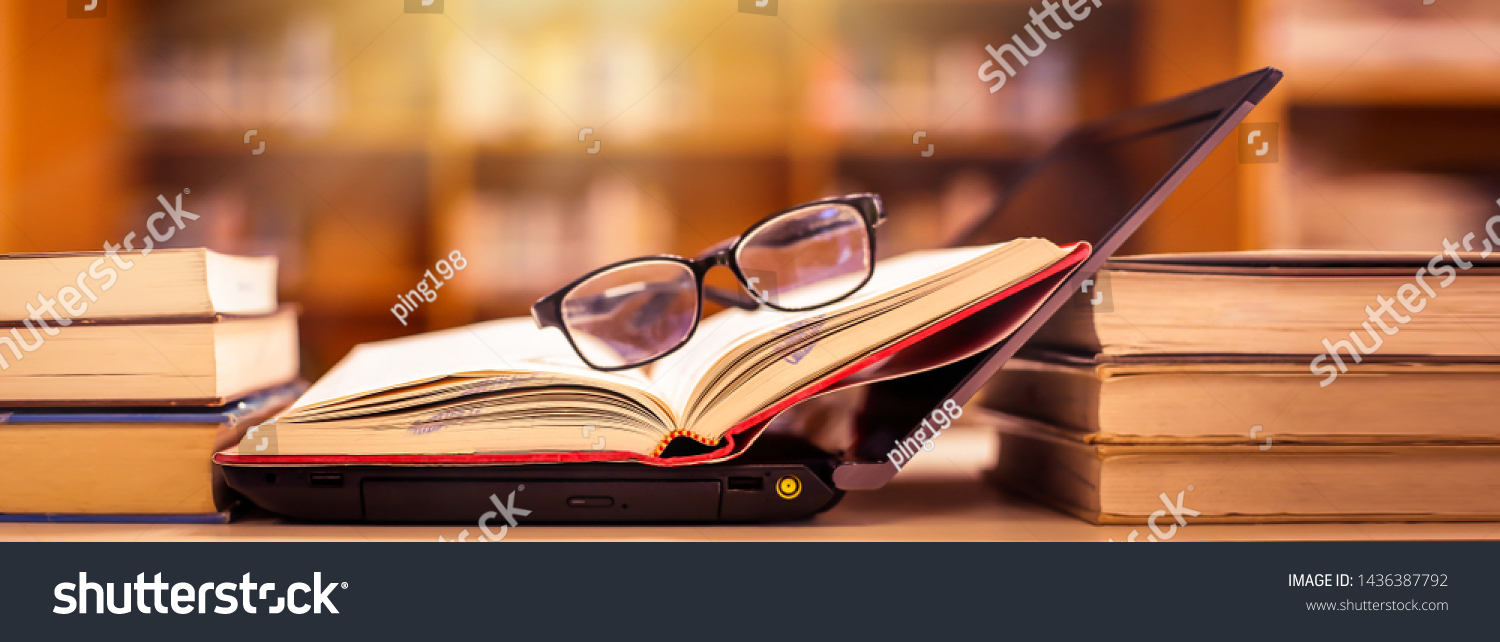 Book in library with old open textbook, stack piles of literature text archive on reading desk, and aisle of bookshelves in school study class room background for academic education learning concept #1436387792