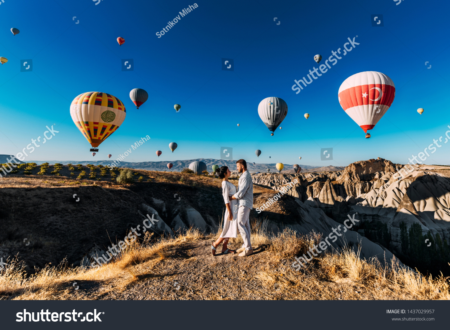 Lovers travel to Turkey. The man proposed to the girl. Family trip to Turkey. Couple at the balloon festival. Honeymoon trip. Couple travels the world. The Landscapes Of Cappadocia #1437029957