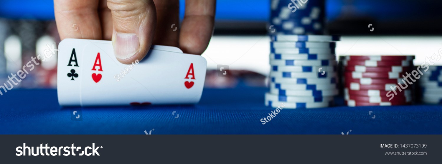 Poker tournament at casino: a player is holding two ace cards #1437073199