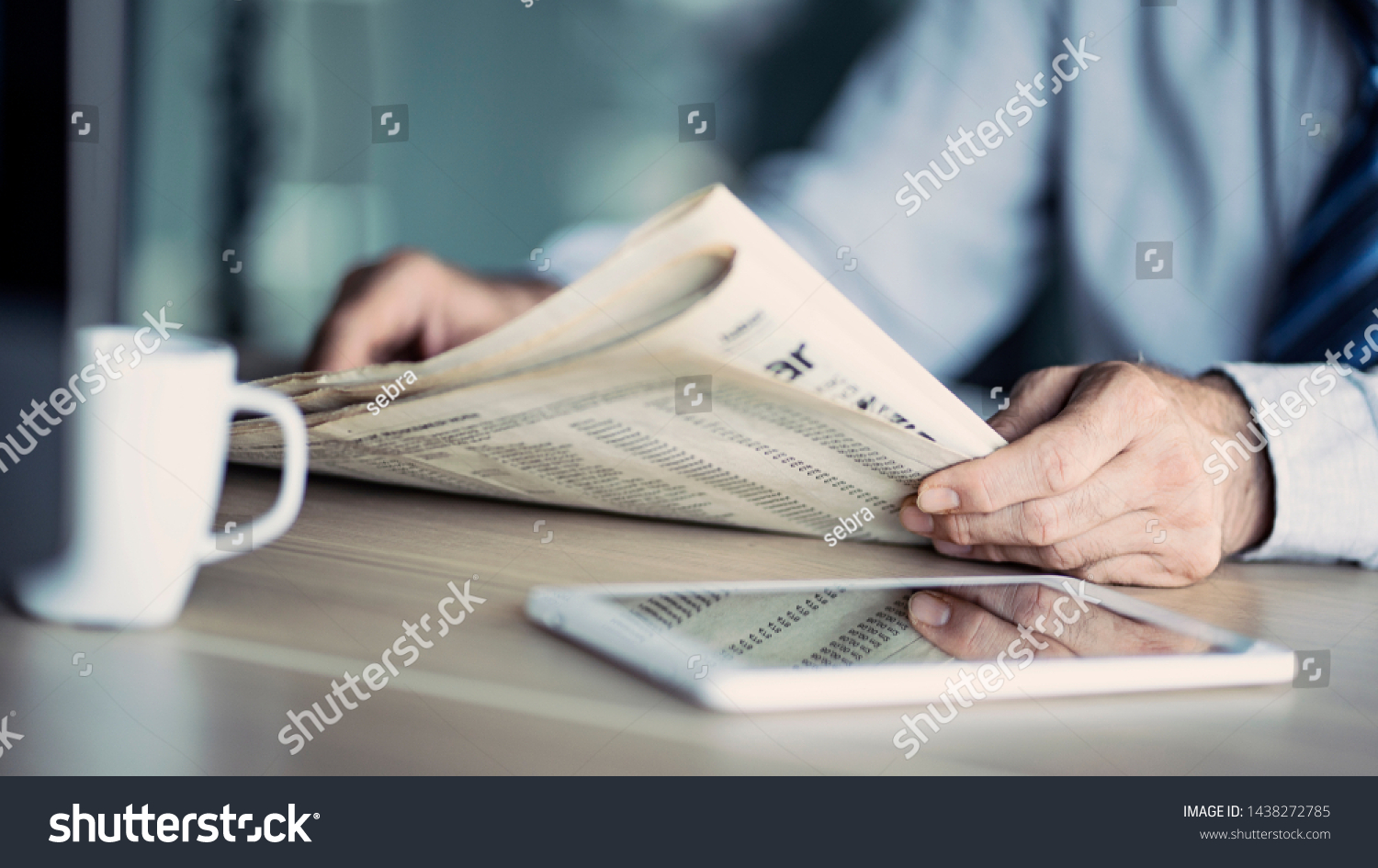 Businessman reading the newspaper on table #1438272785
