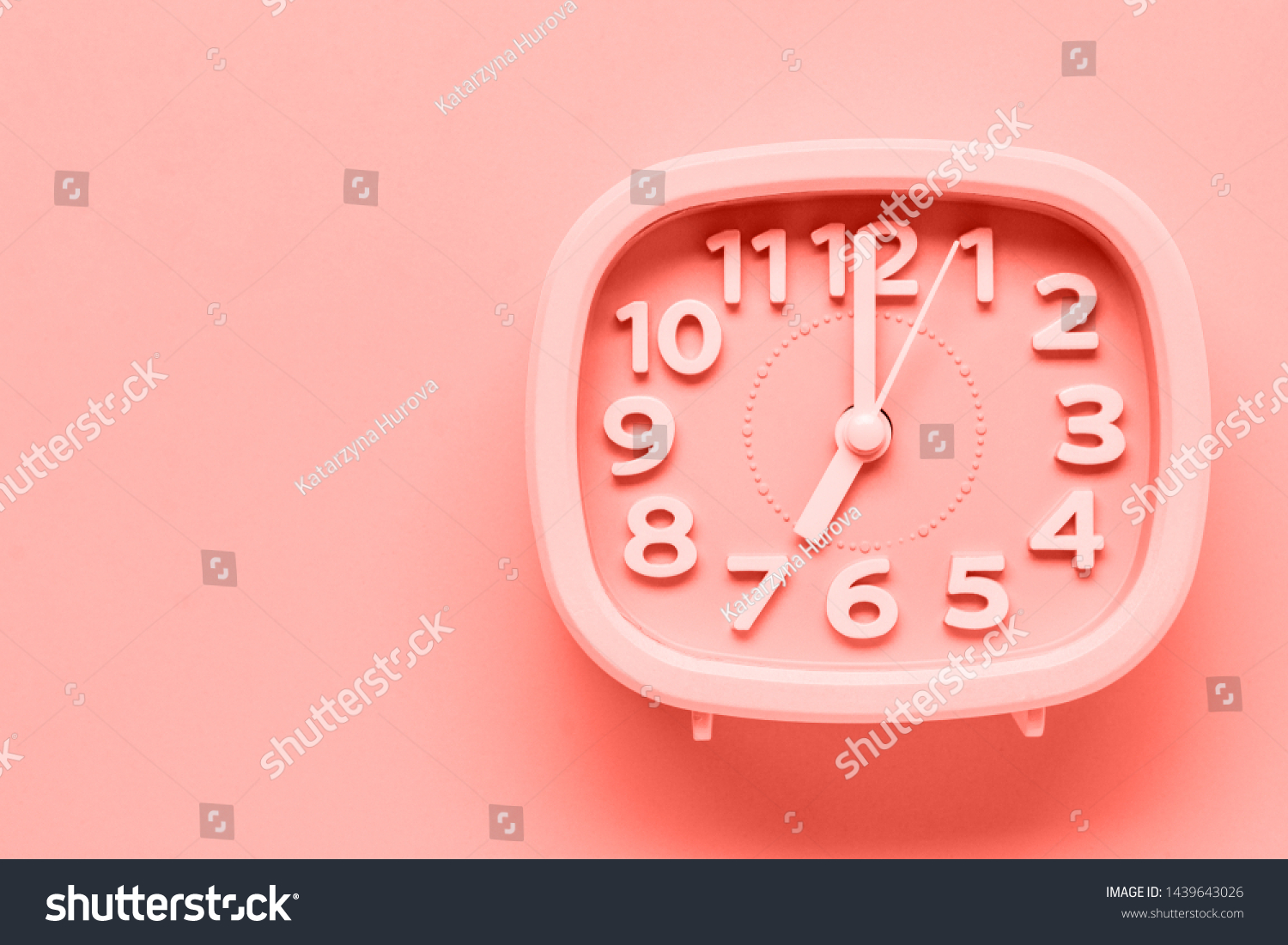 Pink alarm clock lying on yellow surface background. TTrendy living coral color of year 2019.op view.  #1439643026