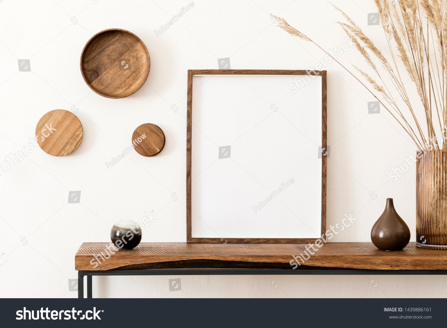 Design scandinavian interior of living room with wooden console, rings on the wall, mock up poster frame, flowers in vase and elegant personal accessories. Modern home decor. Template. #1439886161