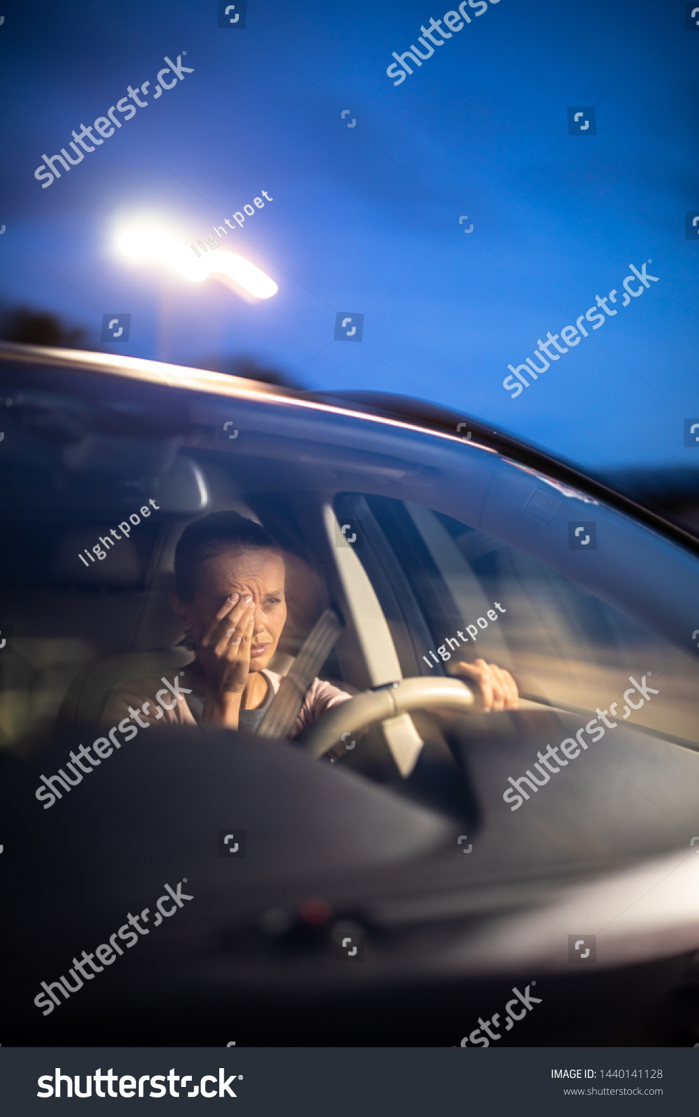 Young female driver at the wheel of her car, super tired, falling asleep while driving in a potentially dangerous situation - Road safety concept #1440141128