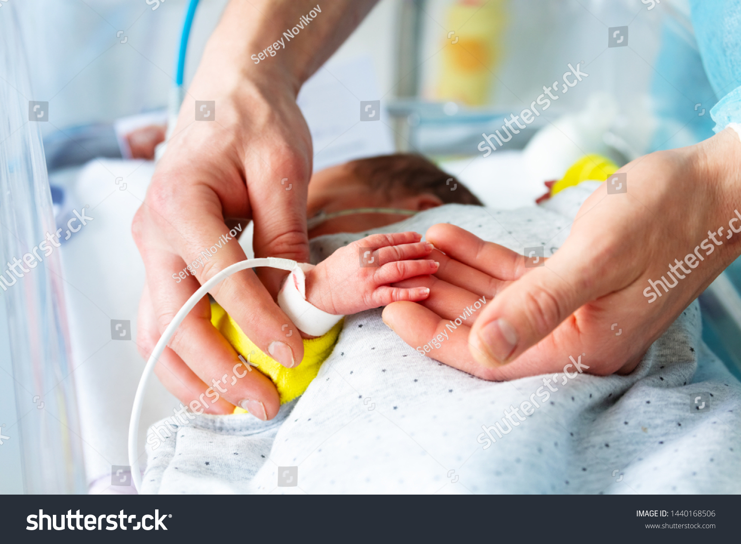 Fathers hand close-up with sick newborn child #1440168506