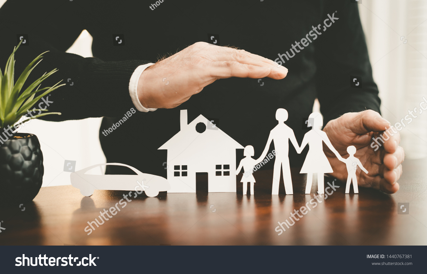 Insurer protecting a family, a house and a car with his hands #1440767381