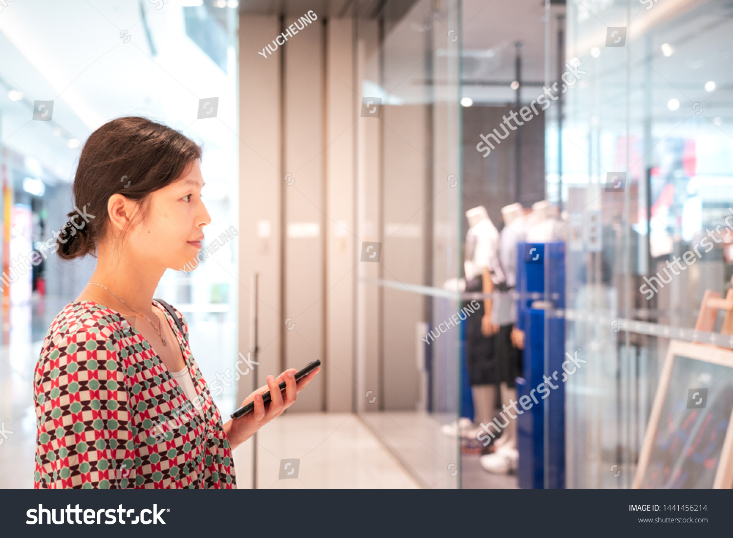 Woman using smartphone inside shopping mall #1441456214