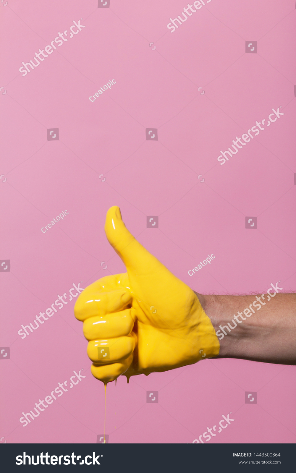 male hand showing sign thumb up with paint flowing down on a colored background. creative idea, creative concept, gesture "class" #1443500864
