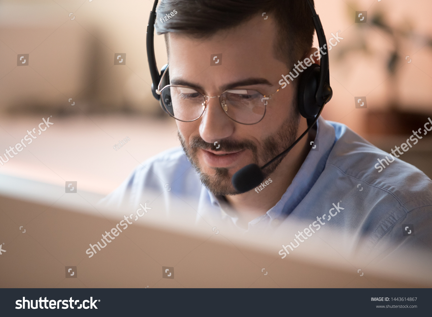 Focused businessman telemarketer telesales agent wear wireless headset make conference video call talk consult online client on computer, male helpline operator work in customer care support office #1443614867