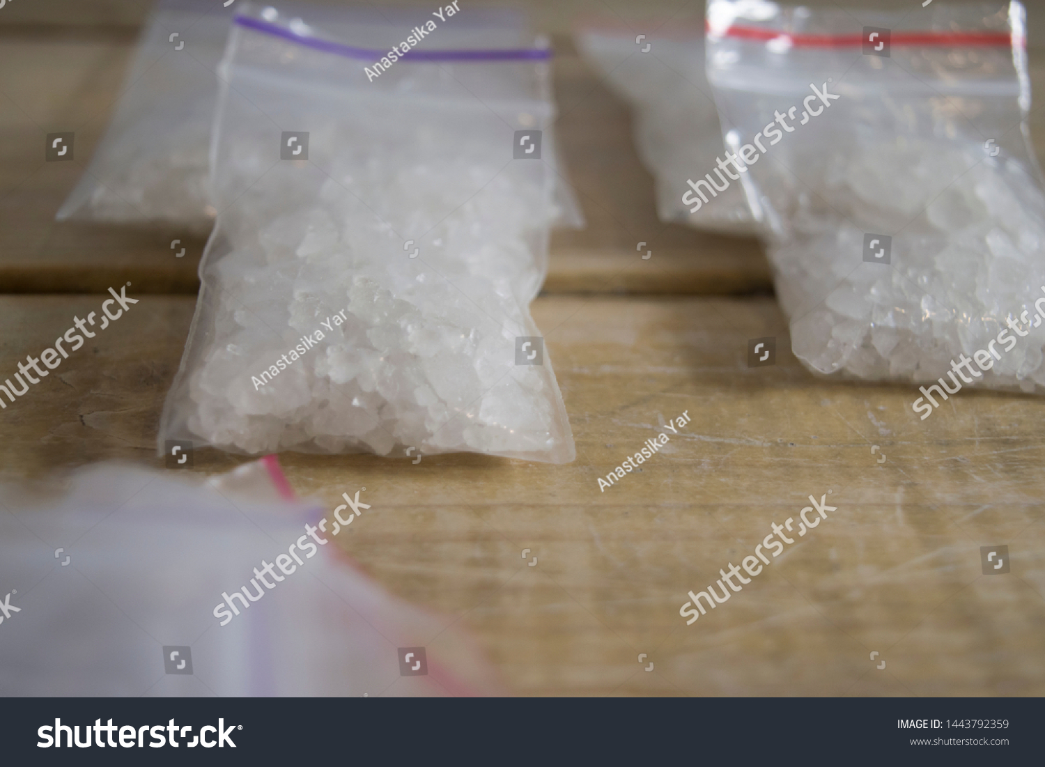 Bath salts drug. Flakka or Alpha-PVP drug. Drug trafficing concept. Illicit substances. Designer drugs. Close up od drug packaging on wooden table. Crystal meth packed. #1443792359