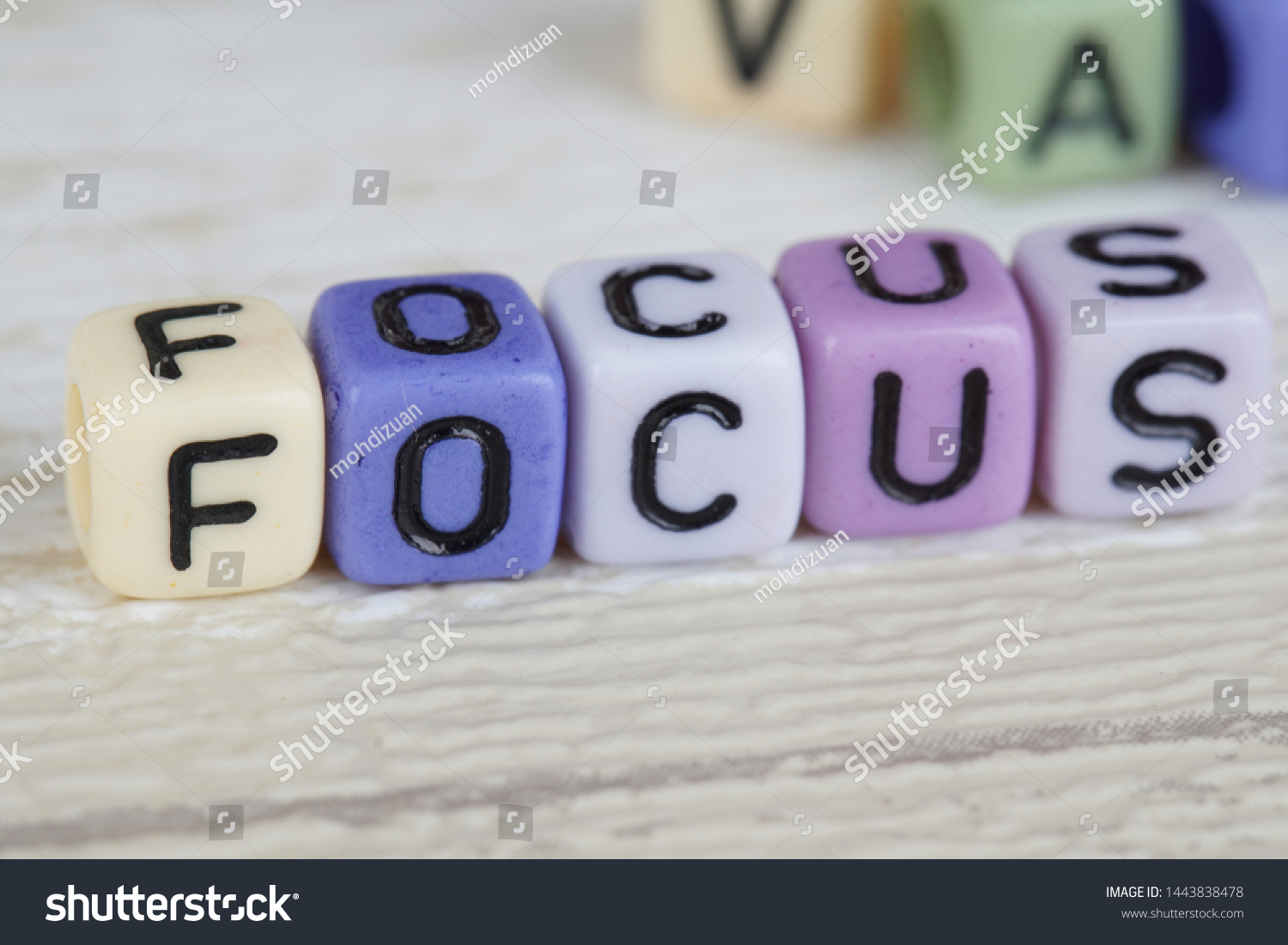 Focus wording from alphabet beads on a wooden surface. selective focus #1443838478