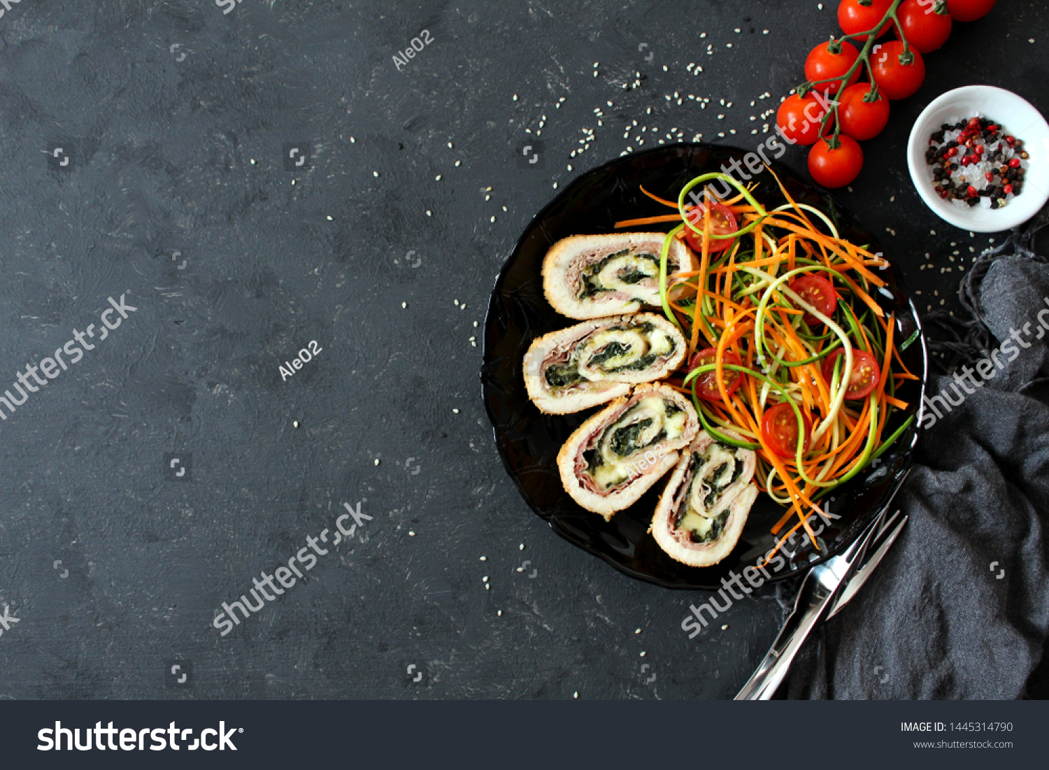 Chicken stuffed with ham, spinach and cheese served with fresh salad on dark background. Top view with copy space. #1445314790