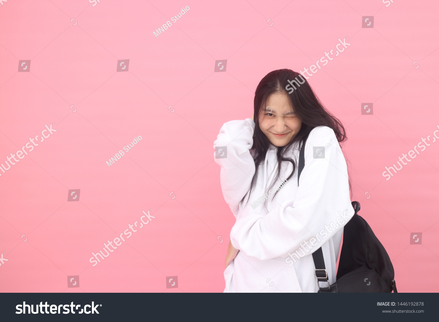 Isolated shot of pretty adult with long hair, broad smile, wears casual outfit, being entertained by friend during party, tilts head and looks with joy, dressed casually, Beautiful Asian models over   #1446192878