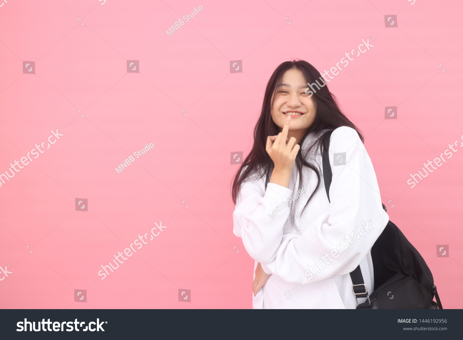 Isolated shot of pretty adult with long hair, broad smile, wears casual outfit, being entertained by friend during party, tilts head and looks with joy, dressed casually, Beautiful Asian models over   #1446192956