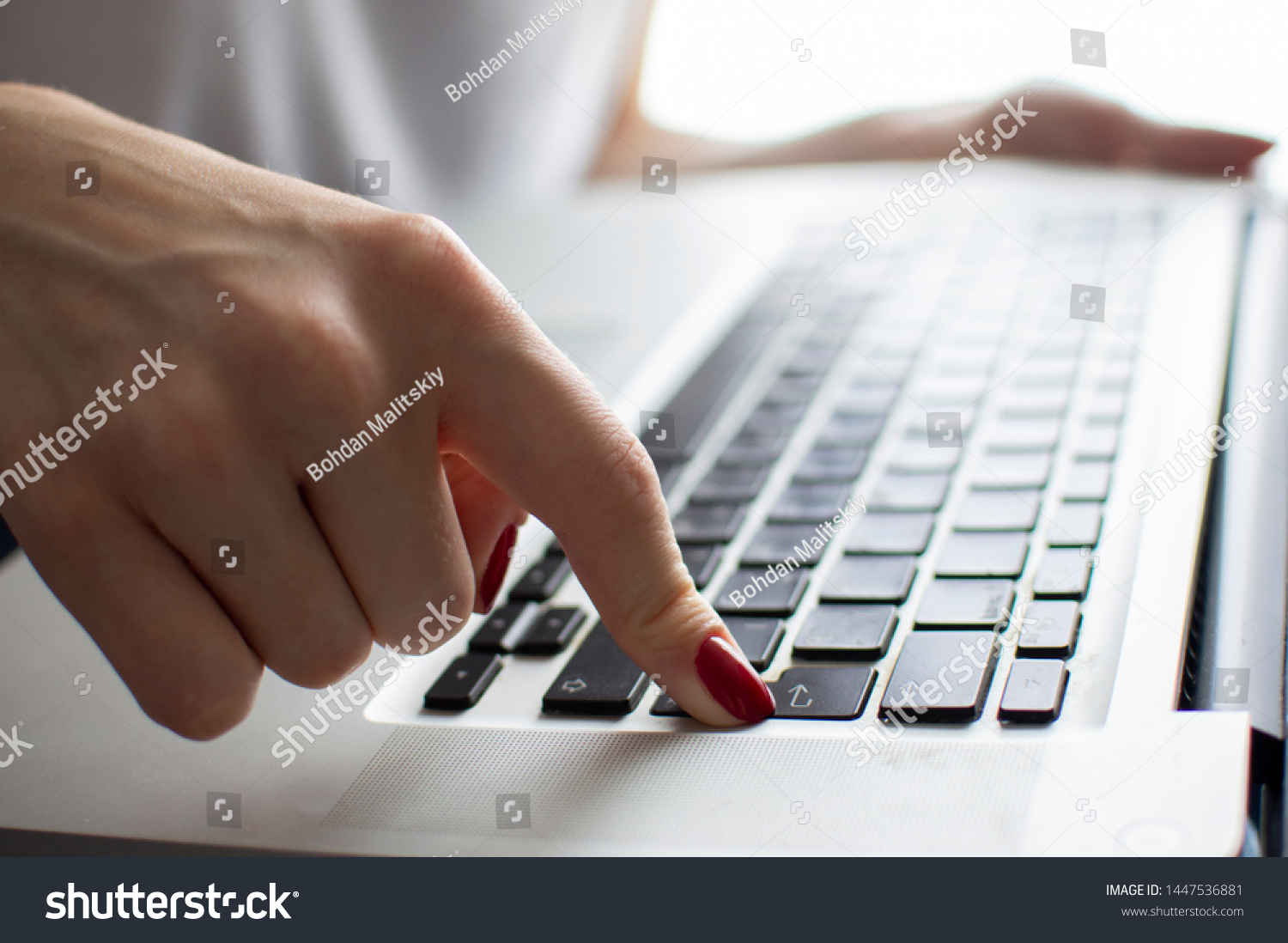 girl's hand typing on a laptop keyboard, she presses Enter key, moment of confirmation on the computer, close-up #1447536881