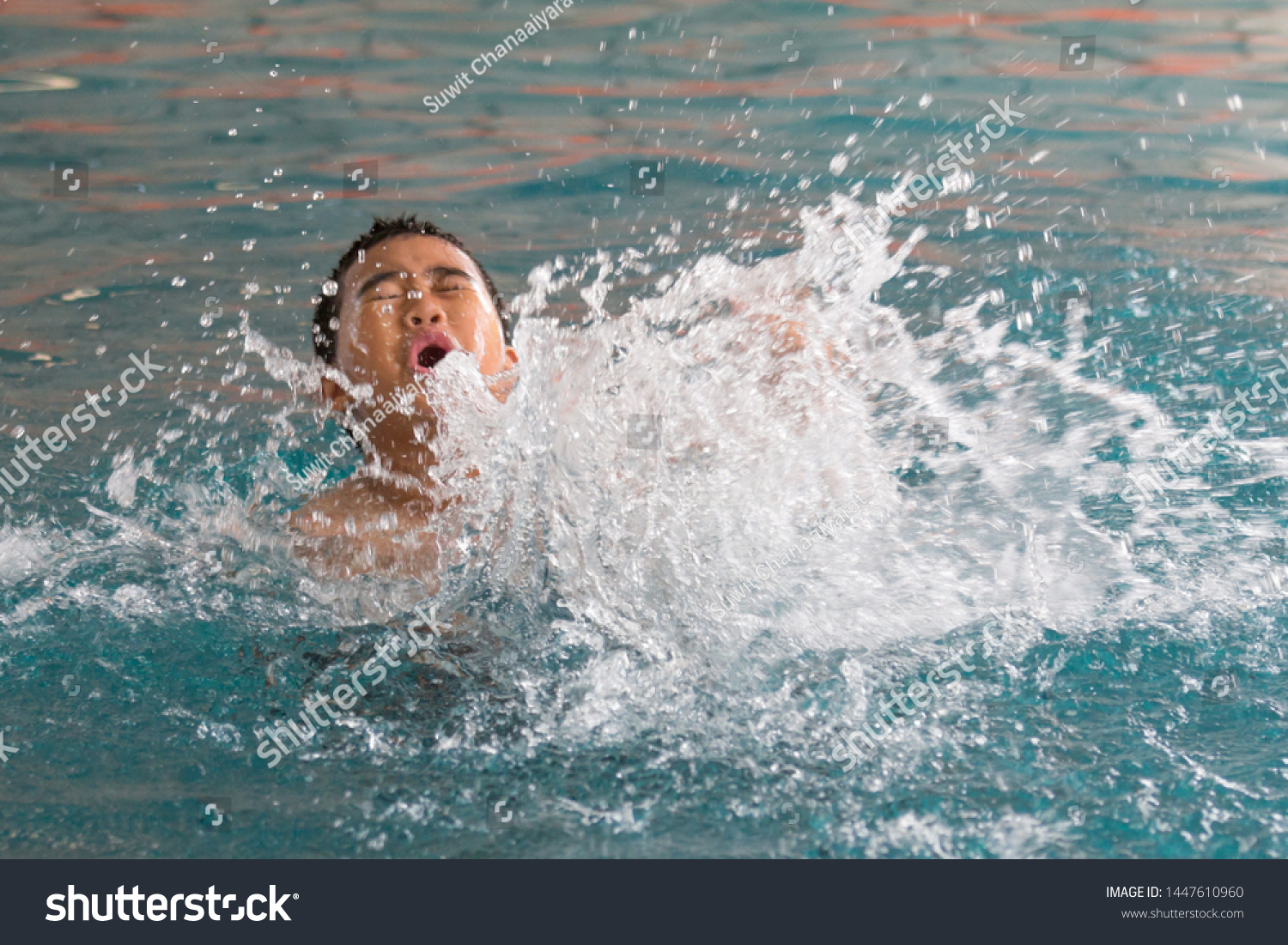  young boy splashing in swimming poll,  #1447610960