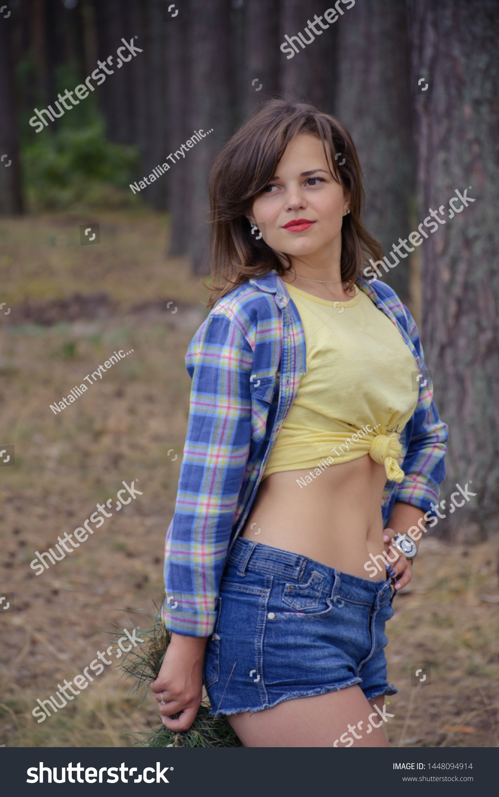 Beautiful young woman in blue shorts walks in - Royalty Free Stock ...