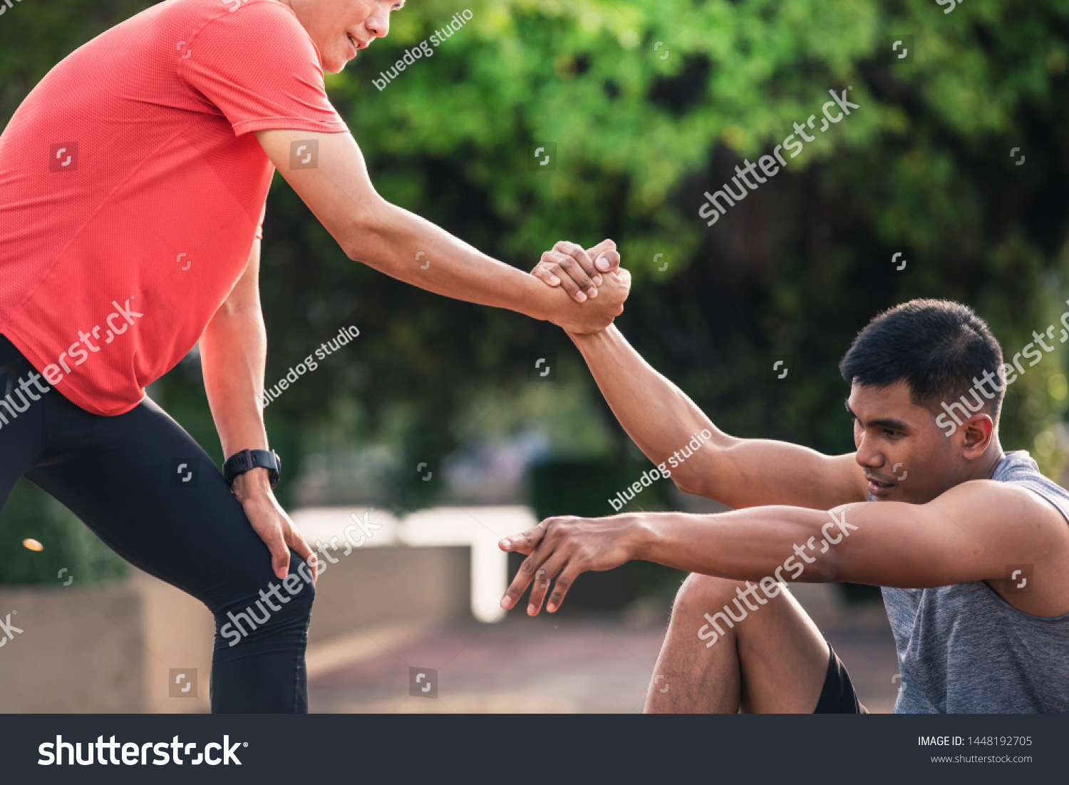 Helping hand outstretched for salvation . Strong hold. Running man helping his friend. Man help each other to run on the running track.
 #1448192705
