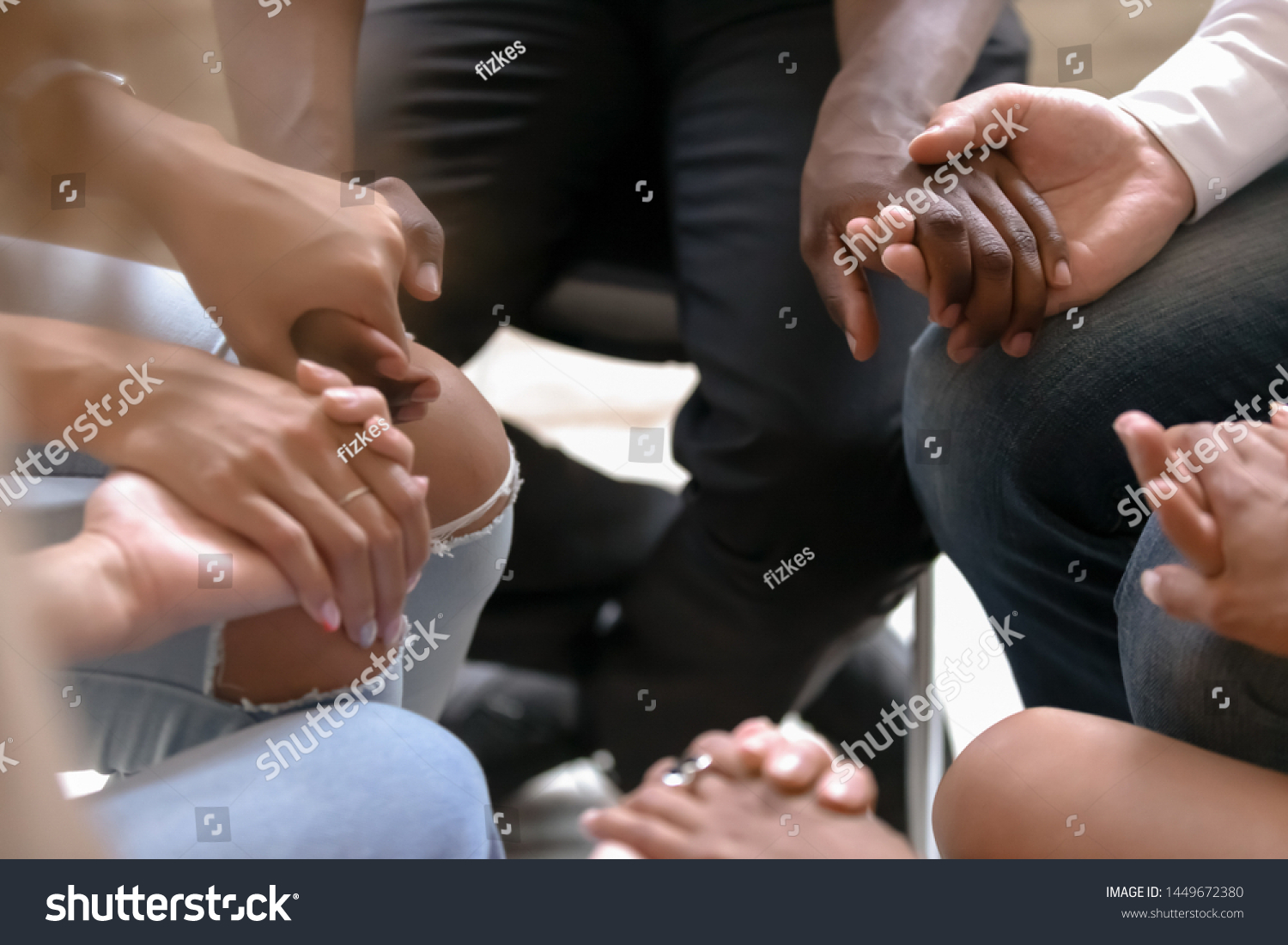 Close up diverse people sitting on chairs in circle, holding hands at group therapy counselling session, psychological help, trust and support, drug alcohol addiction treatment rehab concept #1449672380