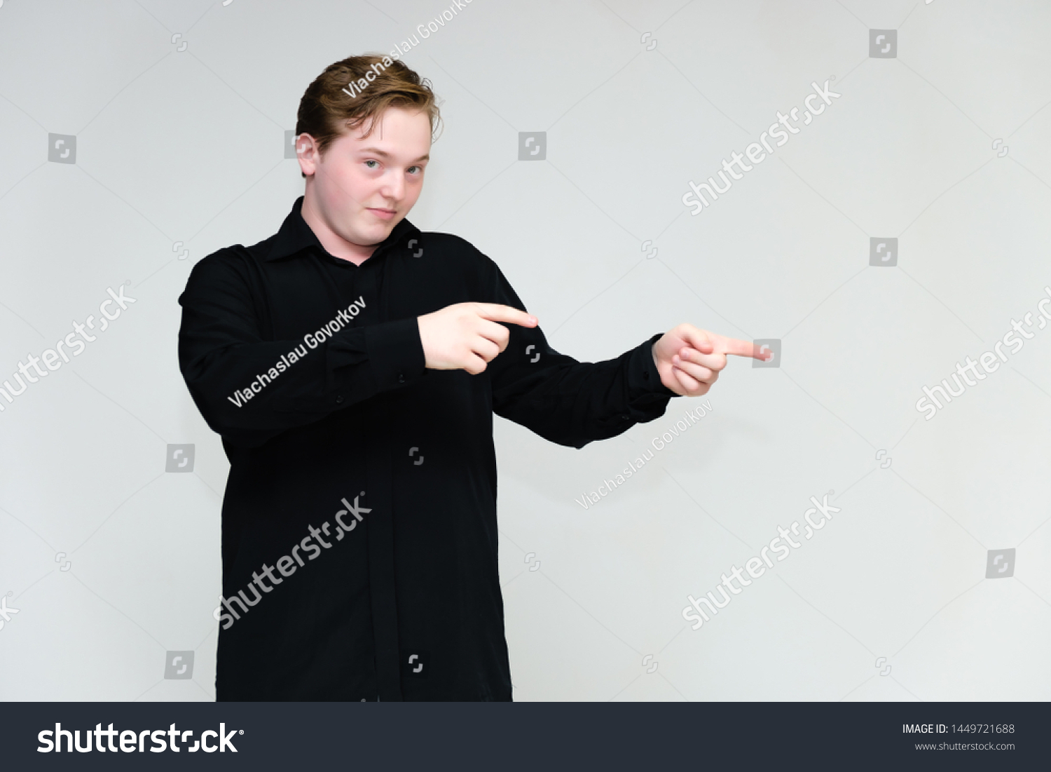 Portrait to the waist on a white background of a handsome young man in a black shirt. stands directly in front of the camera in different poses, talking, showing emotions, showing hands. #1449721688