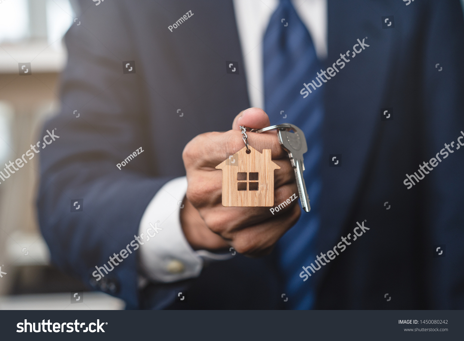 Close up view realtor broker holding home keychain in his hand. #1450080242